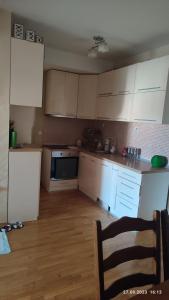 a kitchen with white cabinets and a wooden floor at Apartments Luna Kumanovo in Kumanovo