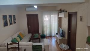 Apartments Luna Kumanovo في كومانوفو: غرفة معيشة بها أريكة بيضاء وتلفزيون