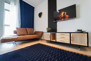 sala de estar con sofá y TV en la pared en central Suite, en Viena
