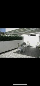 a patio with two chairs and a table and an umbrella at APPARTAMENTO Exclusive in Marsala