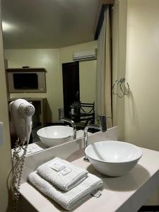 a bathroom with two sinks and a large mirror at Hotel Apolo XVI in Criciúma