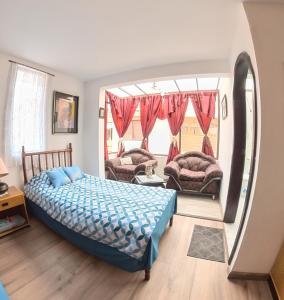 a bedroom with a bed and a large window at Estancia el Capulí in Cuenca
