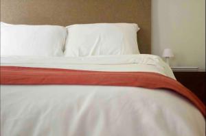 a bed with white pillows and a red blanket on it at comfortable and cool suite in Polanco with GYM in Mexico City