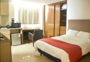 a hotel room with a bed and a kitchen at comfortable and cool suite in Polanco with GYM in Mexico City