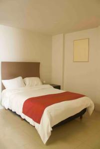 a bedroom with a large bed with a red blanket at comfortable and cool suite in Polanco with GYM in Mexico City