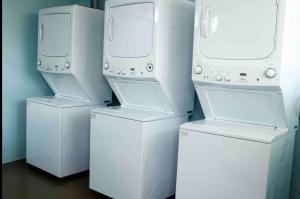 three washer and dryers are lined up against a wall at comfortable and cool suite in Polanco with GYM in Mexico City