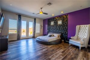 a bedroom with a bed and a purple wall at 3400 SqFt House W/40Ft Heated Pool/Spa- Strip View in Las Vegas