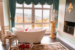 a bathroom with a tub and a large window at Le Boutique Hotel Gramado - Exclusivo para Casais in Gramado