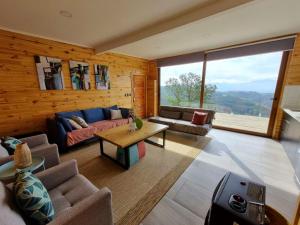 sala de estar con sofá y mesa en Mini casa en lo alto de la montaña en Valparaíso