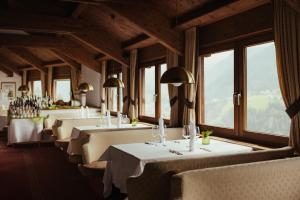 a row of tables in a restaurant with windows at Hotel Grien in Ortisei