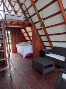 een zolderkamer met een bed en een stoel bij Glamping RanchoEmilio in Villavicencio