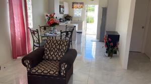 a living room with a chair and a kitchen at CrearyStays in Discovery Bay