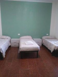 a room with three beds with a bench in it at Appartamento 4 - NEW in Comezzano