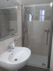 a white bathroom with a sink and a shower at Appartamento 4 - NEW in Comezzano