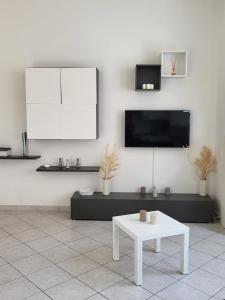 un soggiorno con tavolo bianco e TV di White Home Forli Centro a Forlì