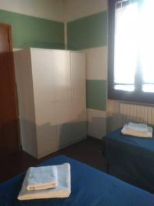 Habitación pequeña con 2 camas y ventana en Appartamento 4 - NEW, en Comezzano