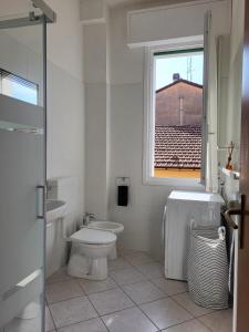 uma casa de banho branca com um WC e uma janela em White Home Forli Centro em Forlì