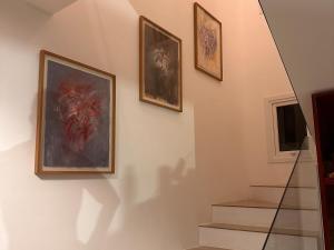 una escalera con tres cuadros enmarcados en la pared en PIPA Magnifique villa moderne en front de mer, en Tibau do Sul