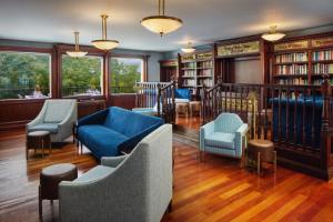 biblioteca con divani e sedie in camera di Irish Cottage Inn & Suites a Galena
