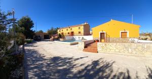 żółty dom z basenem na dziedzińcu w obiekcie Los ferreles 