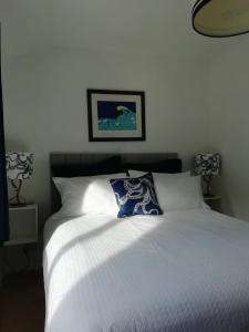 a white bed with a blue pillow on top of it at 2 bed Villa with full use of site facilities in Newquay