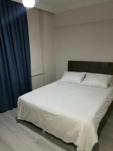 a bedroom with a large white bed with blue curtains at Ege Palace in Istanbul