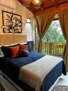 a bedroom with a blue bed and a balcony at Bombinhas Guest House in Bombinhas