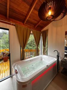 a large bath tub in a room with a ceiling at Bombinhas Guest House in Bombinhas