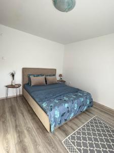 Schlafzimmer mit einem Bett mit blauer Decke und einem Tisch in der Unterkunft Bajka centar in Bosanska Gradiška