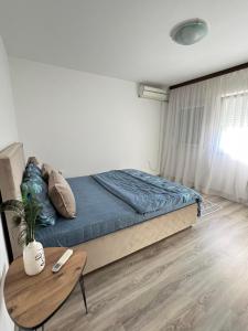 1 dormitorio con cama y mesa de madera en Bajka centar, en Bosanska Gradiška
