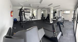 un gimnasio con cintas de correr y máquinas en una habitación en Studio GO Poços en Poços de Caldas