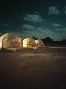 a group of domes in the desert at night at Darien Luxury Camp in Wadi Rum