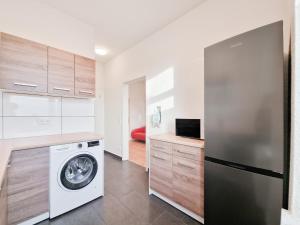 a kitchen with a washing machine and a refrigerator at RAJ Living - 1 or 4 Room Apartments - 15 Min to Messe DUS - 10 Min Old Town DUS in Düsseldorf