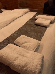 a bed with three white towels on it at AYDER BUNGALOW - river view , Royal Bungalow Resorts in Çamlıhemşin