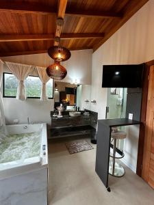 a bathroom with a large tub and a sink at Bombinhas Guest House in Bombinhas