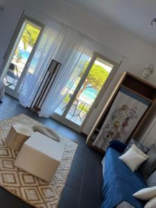uma sala de estar com um sofá e duas janelas em Villa Olimpia em Mondello