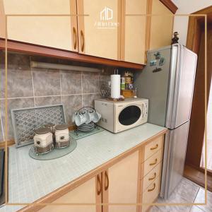 a kitchen with a microwave and a refrigerator at ALL IN ONE APARTMENT GJAKOVA in Gjakove