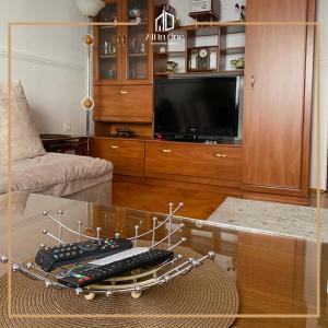 sala de estar con TV y mesa de cristal en ALL IN ONE APARTMENT GJAKOVA, en Gjakove