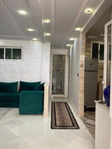 Appartement à louer 80 m² à Aourir - agadir في أورير: غرفة معيشة مع أريكة زرقاء وسجادة