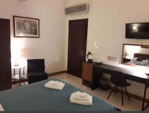 カリアリにあるGuest Room Via dei Passeriのテーブル、デスク、タオル2枚が備わる客室です。