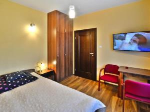 a bedroom with a bed and a desk and a tv at Semi-detached house, Mielno in Mielno