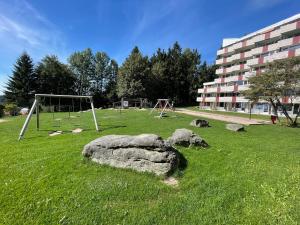 a park with a rock and a swing set at Casa Köstner in Sankt Englmar