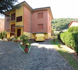 una casa con un coche amarillo aparcado delante de ella en CA' DI SESTO, en Lucca