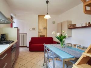 une cuisine avec une table bleue et un canapé rouge dans l'établissement Casa Alex, à Pianello Del Lario 7 autres photos