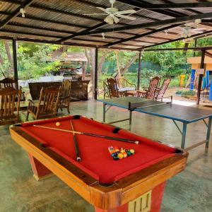 Casa Pura Vida Surf Hostel - Tamarindo Costa Rica في تاماريندو: غرفة بها طاولتين بينج بونغ وكراسي