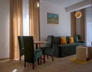 sala de estar con sofá, mesa y sillas en Apart Hotel Gondola Kolasin, en Kolašin