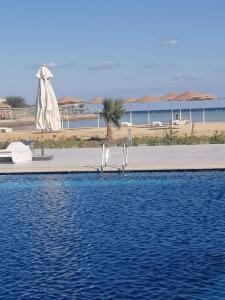 a swimming pool with a statue next to a beach at Scandic Resort One Bedroom Apartment in Hurghada