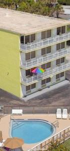 a building with a colorful umbrella and a swimming pool at OB Oceanfront Studio - closest to the beach in Ormond Beach