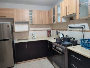 uma cozinha com armários de madeira e um forno com placa de fogão em Casa moderna con cochera en San Isidro Trujillo em Trujillo