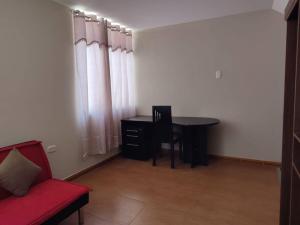 a living room with a desk and a red couch at Casa moderna con cochera en San Isidro Trujillo in Trujillo